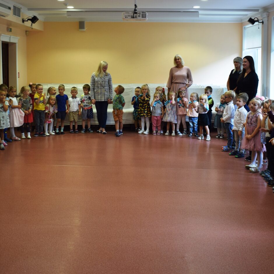 Bērni sapulcējās lielā zālē