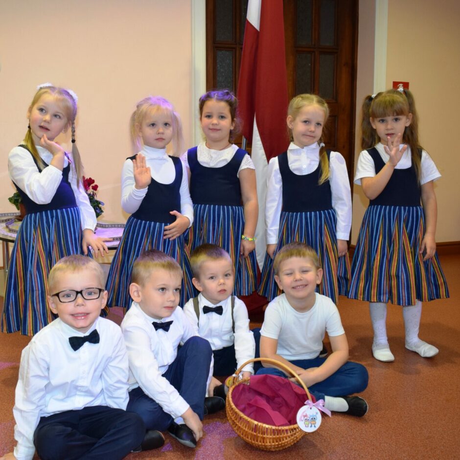 Bērni svin valsts svētkus aktu zālē.