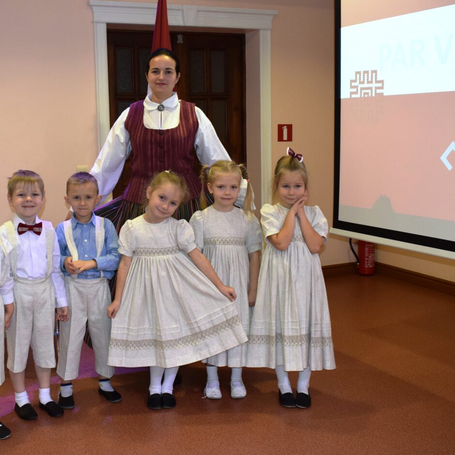 Bērni svin valsts svētkus aktu zālē.