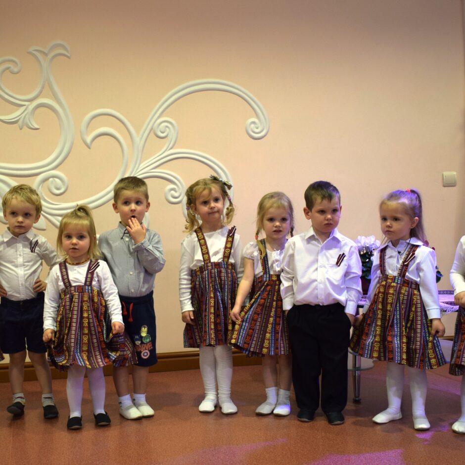 Bērni svin valsts svētkus aktu zālē.