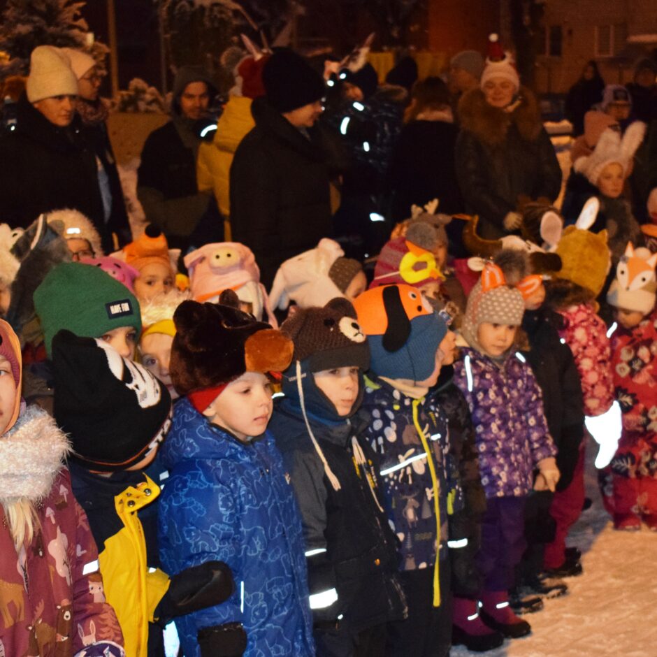 Bērni ar vecākiem stāv pusaplī.