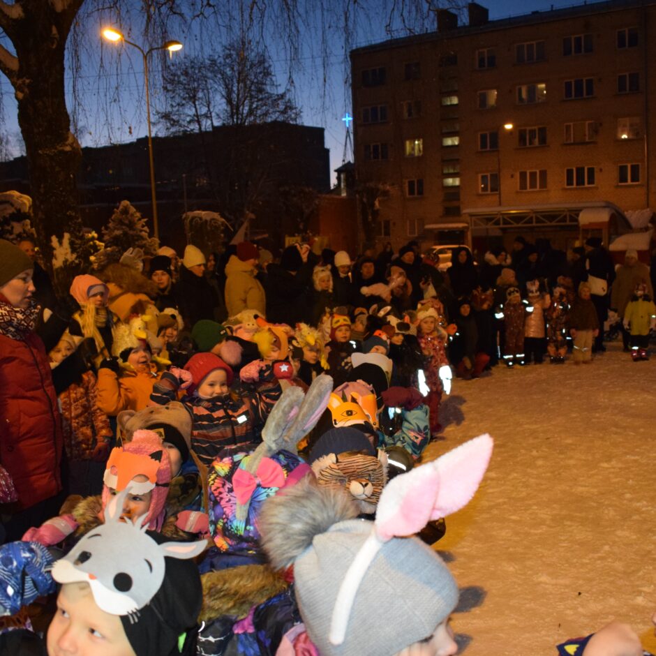 Bērni ar vecākiem stāv pusaplī.