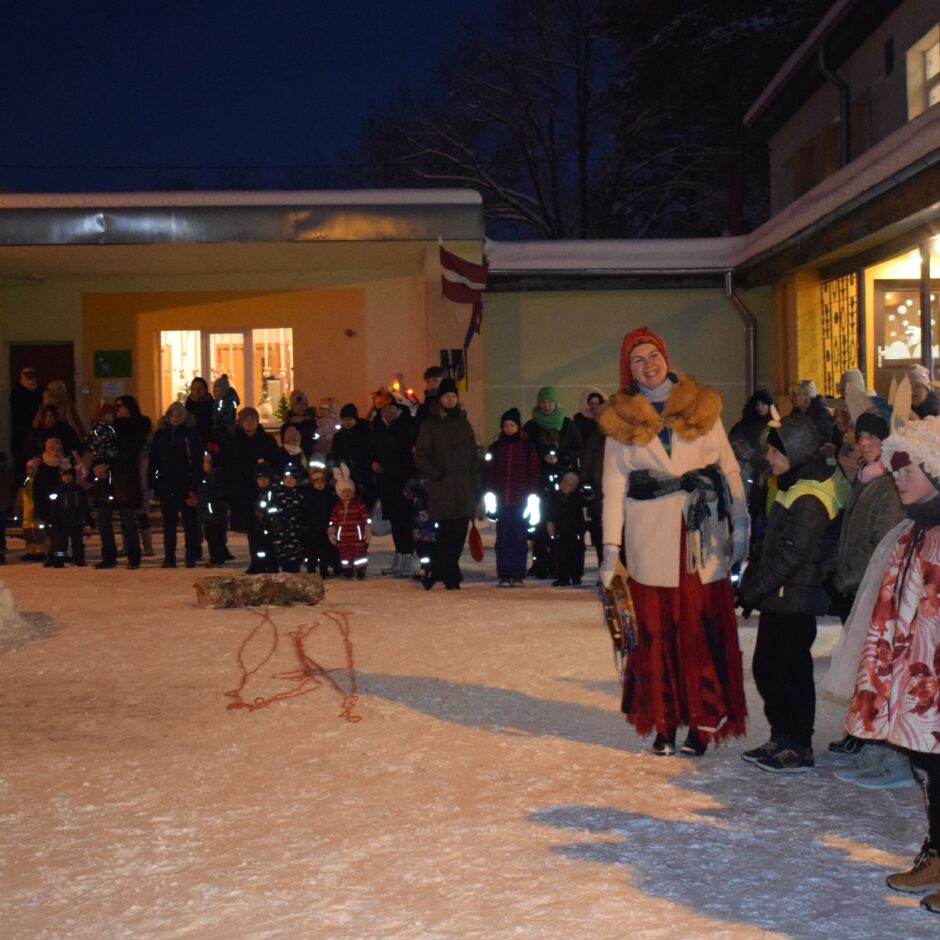 Bērni ar vecākiem stāv pusaplī.