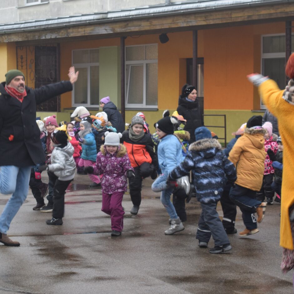 Visas grupas bērnudārza pagalmā dejo jautras dejas.