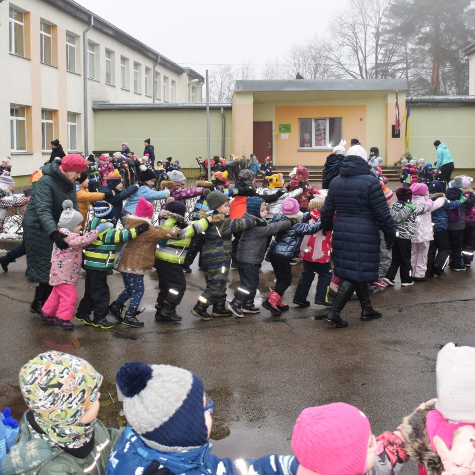 Visas grupas bērnudārza pagalmā dejo jautras dejas.