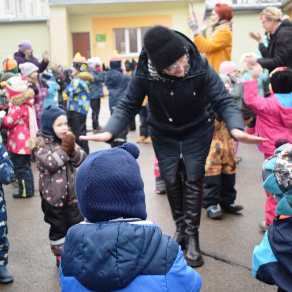 Visas grupas bērnudārza pagalmā dejo jautras dejas.