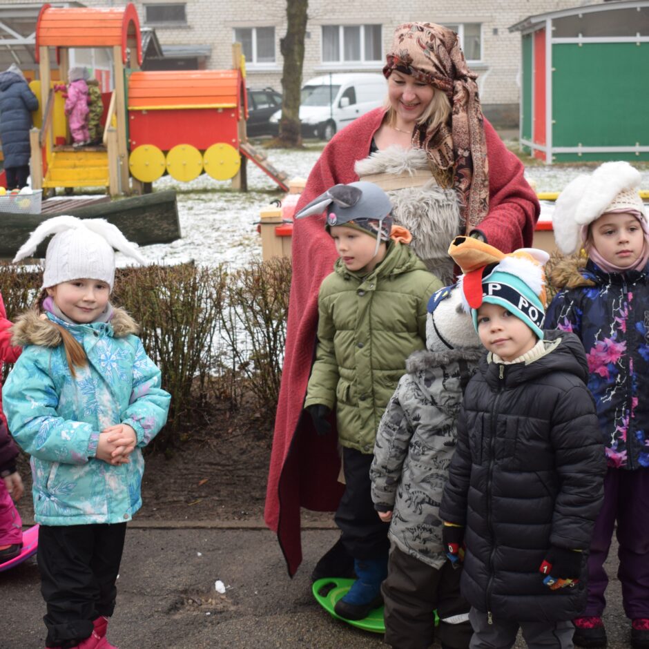 Bērni un skolotāja tērpušies maskās.